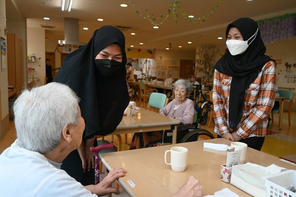 施設利用者と接するインドネシア出身のユリアニさん（左から２人目）＝８月上旬、宇都宮市若松原２丁目