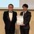 イノベーション賞を手にする西堀専務（右）と授与した能勢剛審査員＝３日、東京都内