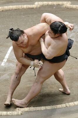 　霧島（左）が寄り倒しで若元春を下す＝両国国技館