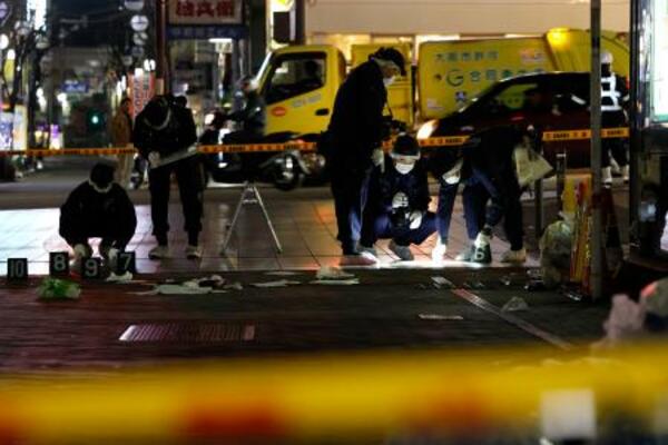 　現場付近を調べる大阪府警の捜査員＝１５日午前３時２０分、大阪市中央区