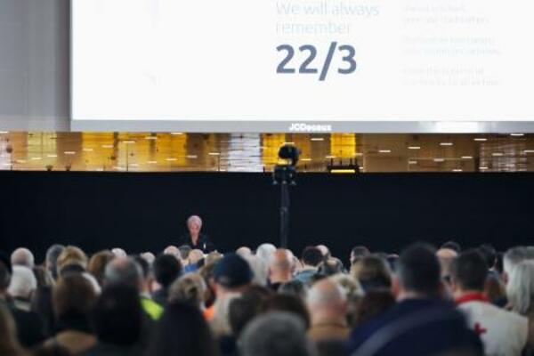 ベルギーのブリュッセル空港での追悼行事で、黙とうする人々=22日(共同)