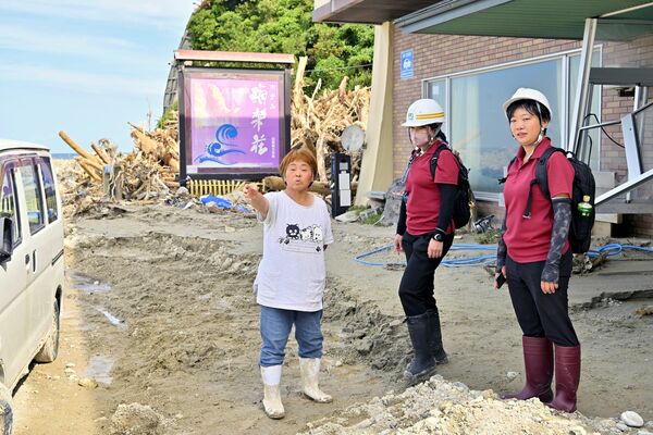 池田真里子さん（左）から土砂災害発生時の様子を聞く風組関東のボランティア＝29日午前10時50分、石川県珠洲市真浦町