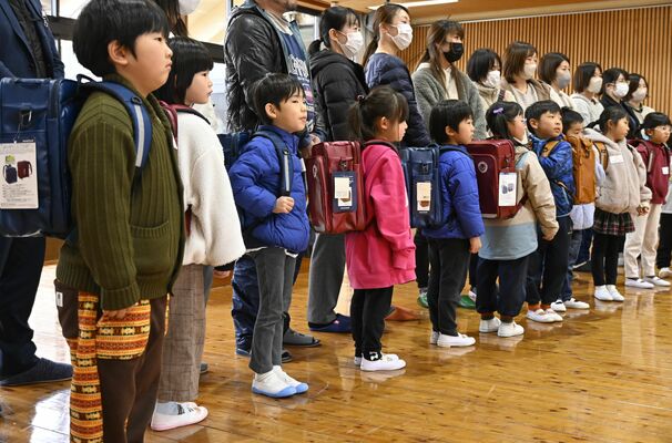 配られたリュックサックを背負う子どもたち