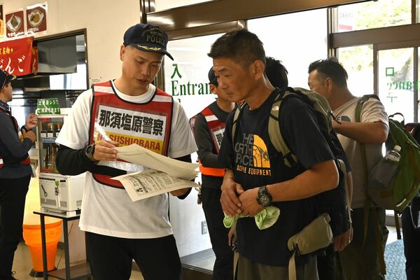 登山客にチラシを手渡す那須塩原署員