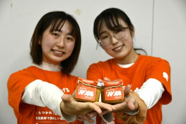 リニューアルした「ご飯にかけるしもつかれ」を手にする石井さん（左）と篠原さん＝26日午後、県庁
