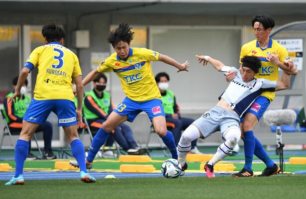競り合う栃木ＳＣのＤＦ福島隼斗ら＝２月19日のホーム熊本戦