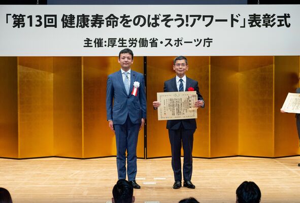 表彰式で表彰状を手にする石川教授（右）