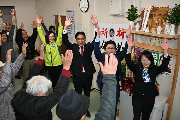 国政に返り咲き支援者と万歳をする柏倉氏（中央）＝９日午前１時、宇都宮市峰４丁目
