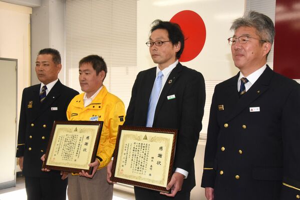 中三川消防長（左）から感謝状を受け取った綱木さん（同３人目）と大森さん（同２人目）