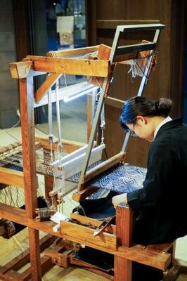 　大島紬を織る織子の伊藤昌代さん。普段も週２回実演している＝東京・銀座（提供写真）