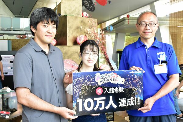 10万人目となった竹村さん夫妻（左、中央）