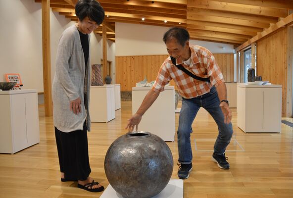 自らの陶芸作品について説明する橋爪さん（右）