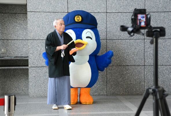 カメラの前で熱演する県警県民広報相談課の津田警部補＝７月下旬、県警本部