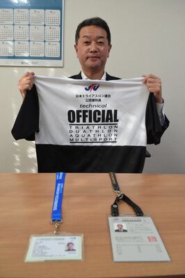 トライアスロンの審判用ユニホームを手にする小島さん。手前は審判のライセンス＝宇都宮市