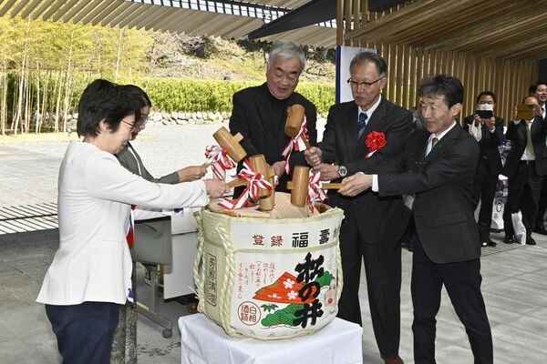 鏡開きで改修完了を祝う隈さん（中央）ら