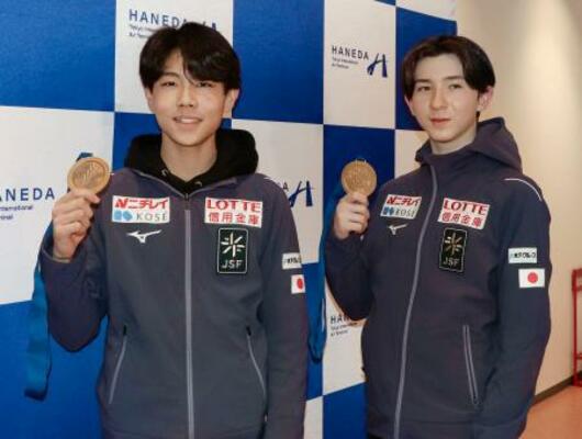 　羽田空港でメダルを掲げるフィギュアスケート男子の中田璃士（右）と西野太翔＝９日
