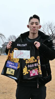 他界した小山田優生さんの名前が入ったファイトパンツを手に勝利を誓う高橋さん＝２月上旬、宇都宮市