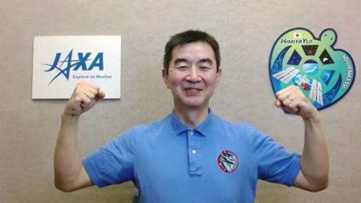 　記者会見で笑顔を見せる宇宙飛行士の油井亀美也さん＝５日午前（ＪＡＸＡの中継から）