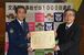 市貝町への感謝状を手にする入野町長（右）と佐藤交通部長