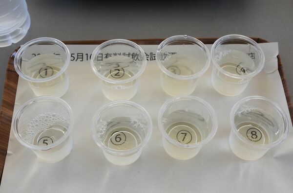 銘柄をブラインドした一升瓶から注がれた８種の日本酒＝５月１６日、さくら市