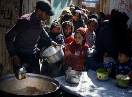　パレスチナ自治区ガザ南部ラファで食事を求める子どもら＝５日（ロイター＝共同）