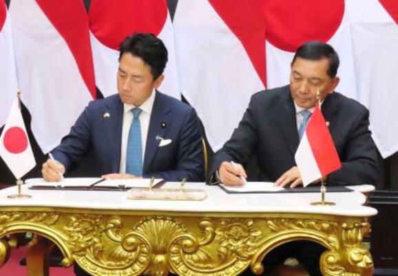 　防衛協力拡大に向けた協定に署名する小泉防衛相（左）とインドネシアのシャフリィ国防相＝４日、ジャカルタ（共同）