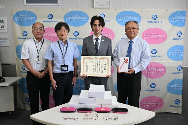 手塚会長（右）に老眼鏡の目録を手渡した松本県央ブロック長