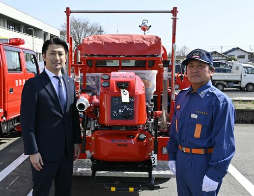 森島市長（左）から小型ポンプを引き渡される金井団長