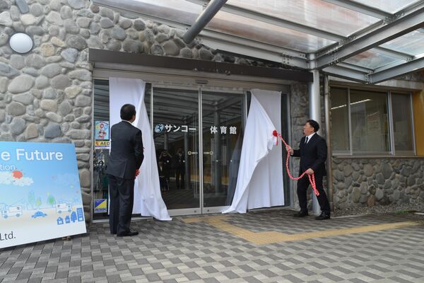 「サンコー体育館」の愛称が披露された除幕式。右がサンコーの阿部社長、左が粉川市長