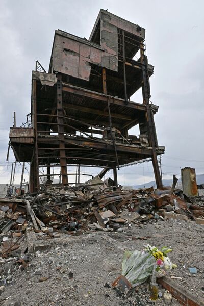 輪島朝市の火災で焼け、鉄骨などがむきだしとなった建物のそばにささげられた花束＝１日午後４時15分、石川県輪島市