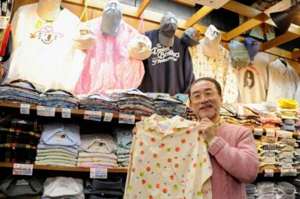 　お薦めのシャツを手にする相羽岳男さん＝東京都台東区