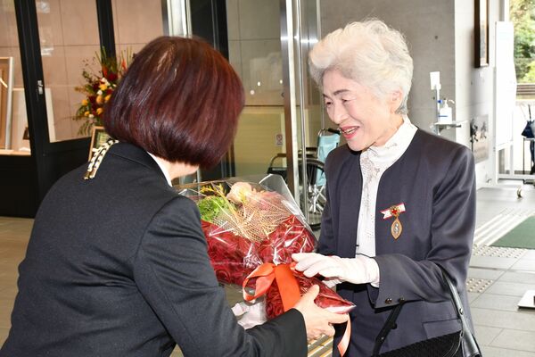 出迎えた職員から花束を受け取る河野さん