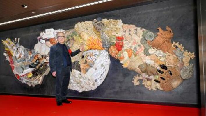 原画や監修を手がけた陶板製の大型レリーフと写真に納まる漫画家大友克洋さん=15日午前、東京メトロ銀座駅構内