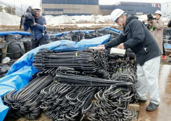 「クリアランス金属」を再利用した鉄筋の放射線量を測定する担当者(右)=18日午後、福井県南越前町