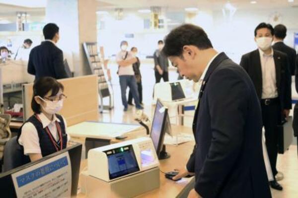 　スマホ保険証を使った受け付けを体験する福岡厚労相（手前右）＝７月、東京都目黒区の東京医療センター
