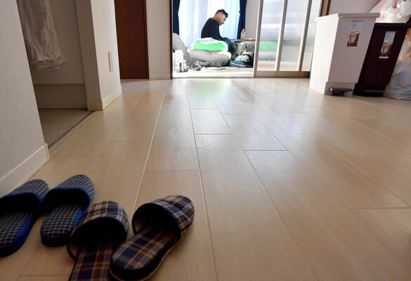 自宅の居間でくつろぐ一生さん（奥）。１人暮らしの室内は掃除が行き届いている＝2023年12月14日午前、日光市内