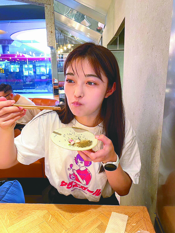 宇都宮市内の店舗でギョーザを頬張る井上さん (提供写真)