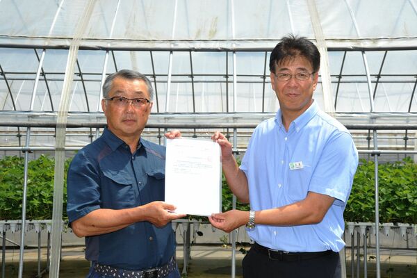県上都賀農業振興事務所の中里所長から認定通知書を受け取る江俣さん（左）
