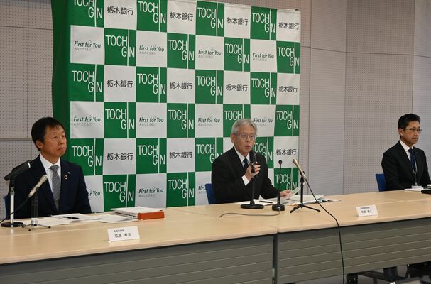 ２０２５年３月期の業績予想修正について説明する仲田頭取（中央）＝26日午後、栃木銀行本店