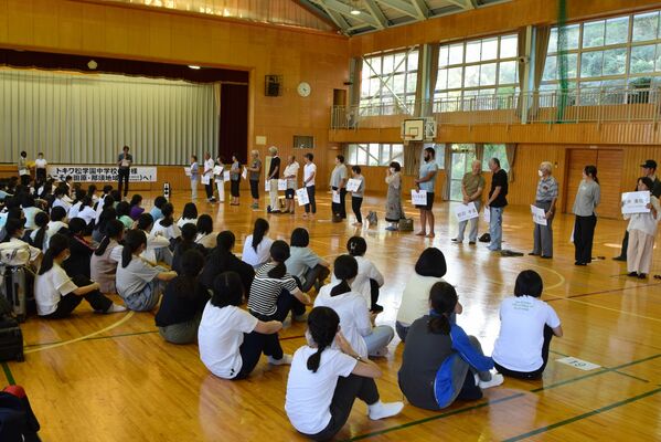入村式で顔合わせをする農家（奥）と生徒