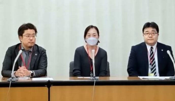 記者会見する小金澤昇さんの妻恵美理さん(中央)と代理人弁護士=6日午後、厚労省