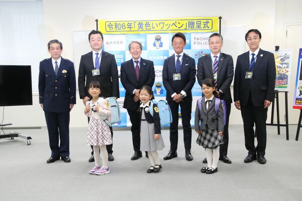 黄色いワッペンを着けてもらった新１年生ら＝７日午前、県警本部（県警提供）