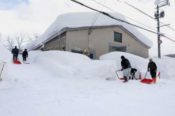 　建物の周囲を除雪する人たち＝２日、青森市
