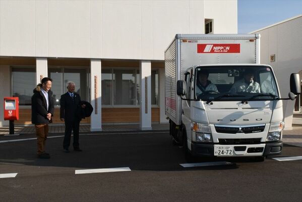被災地支援用のペットボトルの水を載せて出発するトラック