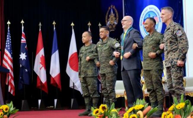 　大規模合同演習「バリカタン」の開幕式で、腕を組んで連帯を表す米国とフィリピンの軍高官ら＝２０日、マニラ（共同）