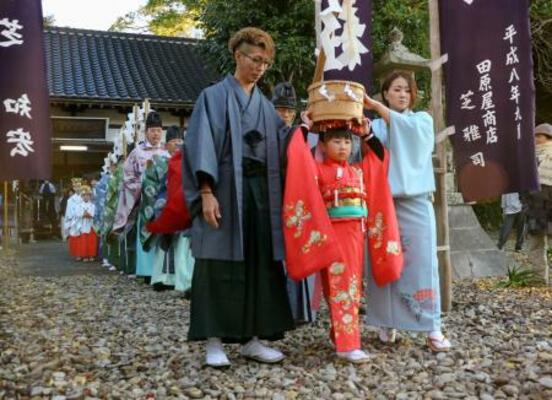 木葉神社の「ねんねこ祭り」で、頭におひつを載せた「ご飯持ち巫女」を先頭に練り歩く行列=7日午前、和歌山県串本町