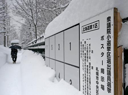 　雪が降り積もった衆院選候補者のポスター掲示板＝２６日、札幌市