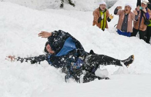 奇祭「むこ投げ」で雪の斜面に投げ落とされ転がる俵山舜平さん=15日午後、新潟県十日町市