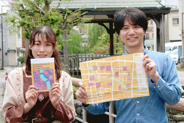 完成した冊子とマップを持つ中村さん（右）と岩田さん