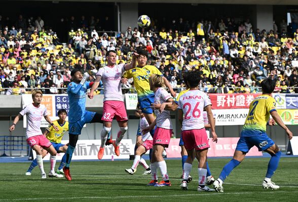 前回の「栃木ダービー」で、空中戦で競り合う栃木シティと栃木ＳＣの選手＝３月30日、カンセキスタジアムとちぎ